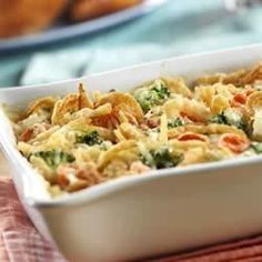 a casserole dish with broccoli, cheese and other food items in it