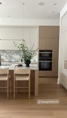 a kitchen with an island, stove and oven next to a dining room table in it