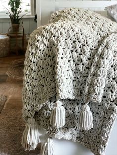 a crocheted blanket with tassels on it