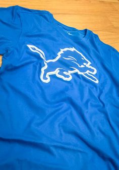 Nike Detroit Lions Blue Essential Logo Short Sleeve T Shirt Nike Tops For Football Season Fan Merchandise, Nike Fan Apparel Tops For Football Season, Blue T-shirt For Football Season Sports, Blue Crew Neck T-shirt For Sports Season, Blue Team Spirit T-shirt For Game Day, Blue T-shirt For Game Day With Team Spirit, Blue T-shirt With Team Name For School Spirit, Nike Tops With Letter Print For Football Season, Blue T-shirt For Team Spirit Fan Gear