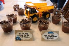 there are many desserts on the table with construction trucks around them and place cards