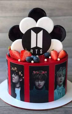 a mickey mouse cake is decorated with photos and strawberries for the top tiers