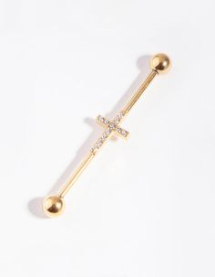 a gold cross piercing with diamonds on it