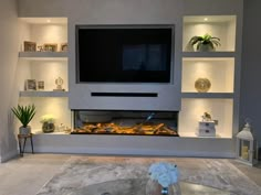 a living room with built in shelves and a flat screen tv mounted on the wall