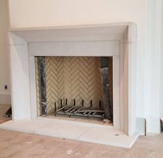 an empty fireplace in a room with white walls