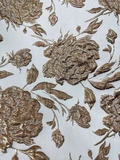 the fabric has gold flowers and leaves on it