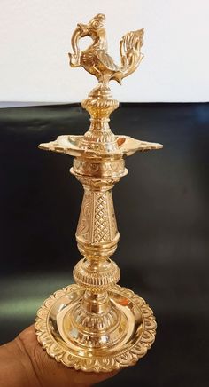 a gold colored candle holder in the shape of a bird