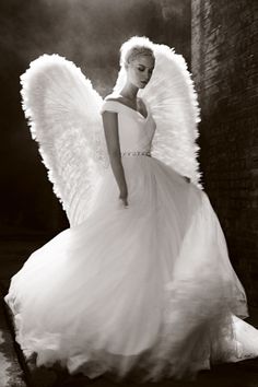 a woman in a white dress with angel wings