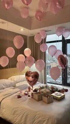 some balloons are hanging from the ceiling above a bed