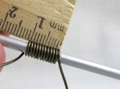 a close up of a person holding a piece of metal with a measuring tape on it