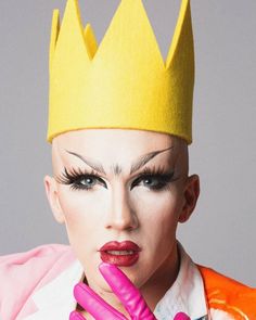 a woman wearing a yellow crown and pink lipstick