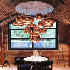 a dining room with a large window and lots of lights hanging from it's ceiling