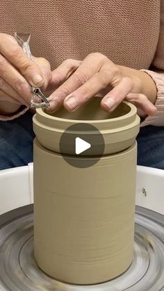 a woman is making a vase out of clay on a spinning wheel with her hands