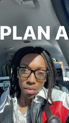 a woman with dreadlocks sitting in the back seat of a car and looking at the camera