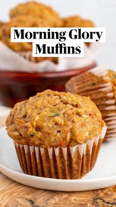 two muffins on a white plate with other muffins in the background