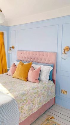 a bedroom with blue walls, pink bed and yellow drapes on the windowsill