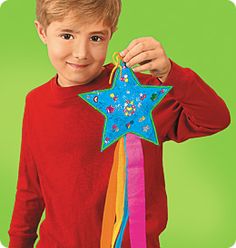 a young boy holding up a star shaped pinata