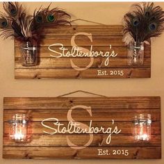 two wooden signs with mason jars filled with candles and some feathers on the top one