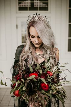 a woman with grey hair wearing a tiara and holding a bouquet of red roses