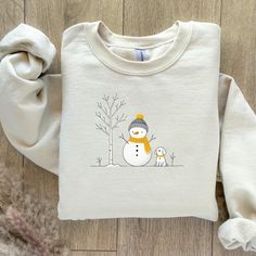 Stay cozy and festive with this adorable Christmas Snowman sweatshirt! It has a cheerful snowman design and is perfect for adding holiday charm to your winter wardrobe. Soft, comfy, and full of Christmas spirit! This item is Made in the USA Fit: -Crew neckline  -Comfy wearing experience with a clean-cut style.  -Double-needle stitching at the shoulder, armhole, neck, waistband, and cuff. -Tear-away label.  Material: -Made using 100% US cotton.  -Fabric blends: Heather Sport colors - 60% polyeste Cute Cotton Winter T-shirt, Cute Cotton T-shirt For Winter, Snowman Sweatshirt, Snowman Sweater, Snowman Shirt, Snowman Design, Sweatshirt Christmas, Snowman Christmas, Christmas Sweatshirts