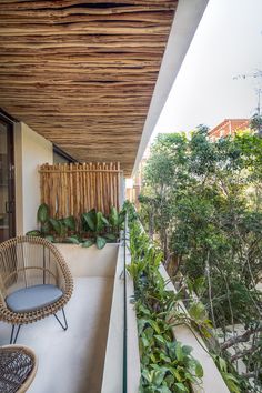 a balcony with wicker furniture and plants on the outside wall, along with wooden slats