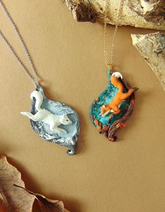 two necklaces that have animals on them