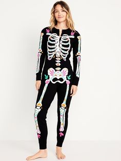 a woman is wearing a skeleton costume and standing in front of a white wall with her legs crossed