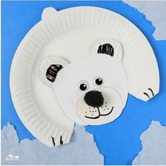 a paper plate with a polar bear cut out of it's face on a blue background