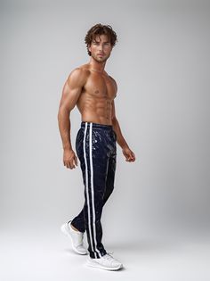 Introducing the stylish PU Nylon Sport Jogging Pants in glossy navy, blending fashion and function seamlessly. Featuring a flexible fit with lacing and an elastic waistband, these pants in elegant navy with white stripes offer a modern and sporty look. With two practical side pockets and a lightweight, breathable feel, they're perfect for on-the-go activities. Available in sizes S to 2XL and lengths from 97 cm to 115 cm, these pants provide comfort and style for any occasion. Elevate your sports Metallic Athleisure Bottoms For Sports, Fitted Nylon Bottoms With Reflective Details, Sporty Navy Nylon Pants, Nylon Pants, Jogging Pants, Dynamic Poses, Action Poses, Sporty Look, White Stripe