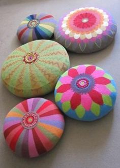 four brightly colored round cushions sitting on top of a table