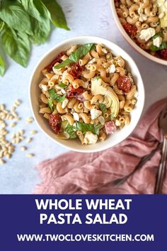 two bowls filled with pasta salad on top of a pink napkin next to silverware