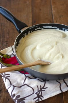 a pan filled with batter sitting on top of a wooden table next to a spatula