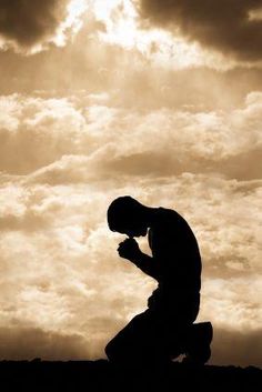 a man kneeling down in front of a cloudy sky