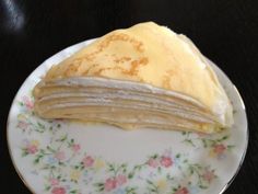 a stack of pancakes sitting on top of a white and pink plate with flowers around it