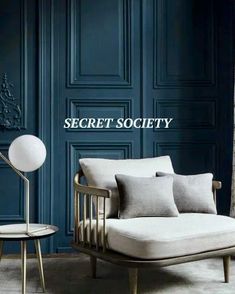 a couch and chair in front of a blue wall with the words secret society on it