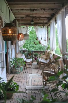 an outdoor porch with wicker furniture and hanging lights on the ceiling, surrounded by greenery