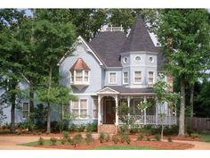 a large blue house with white trim on the front porch and two storyed windows