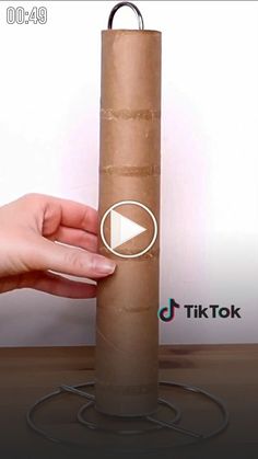 a person holding a roll of brown paper in their hand with the video below it