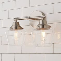 two light fixtures mounted on a white tiled wall