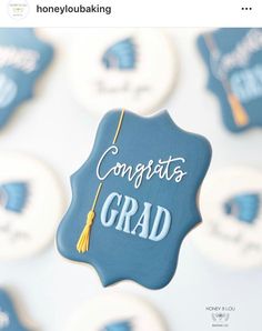 congratulations grad cookie with blue icing and yellow tassels on it's top