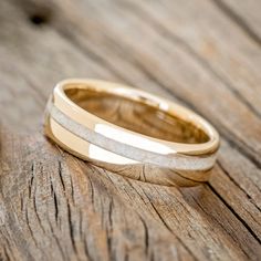 two wedding bands sitting on top of a wooden table