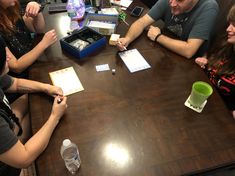 a group of people sitting around a wooden table