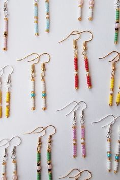 many different colored beads are hanging from earrings