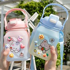 two children's water bottles with hello kitty stickers on them