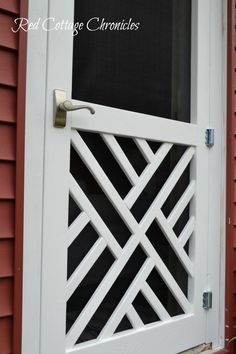 a close up of a white door on a red house with black and white trim