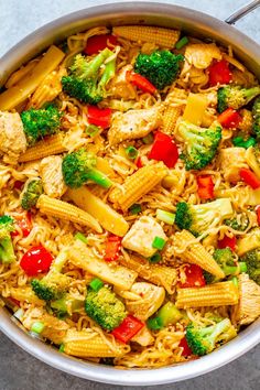 a pot filled with pasta and vegetables on top of a table