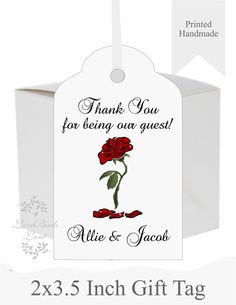 a white gift tag with a red rose on it