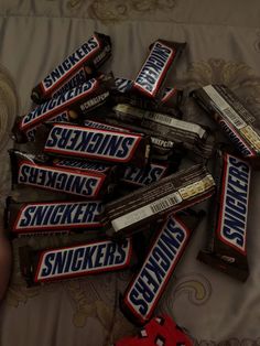 a pile of snickkers sitting on top of a bed