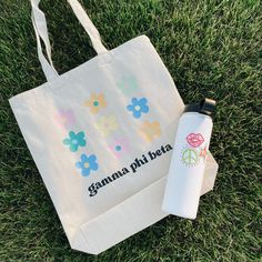 a tote bag and water bottle sitting on the grass