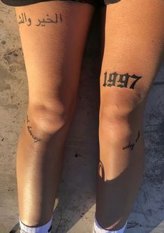 the legs and ankles of a person with tattoos on their arms, both showing numbers